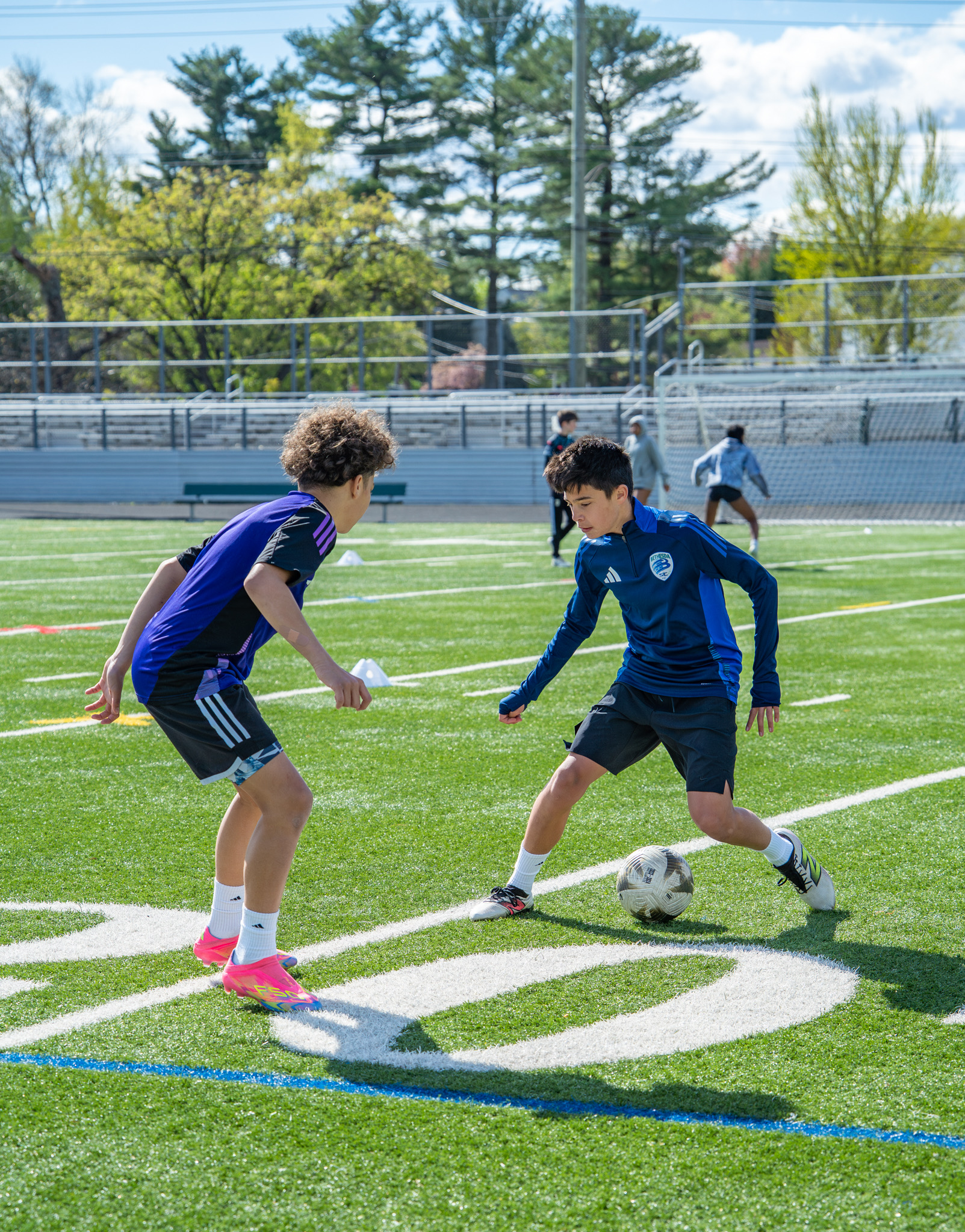 Two players in a 1v1 dribbling matchup on turf