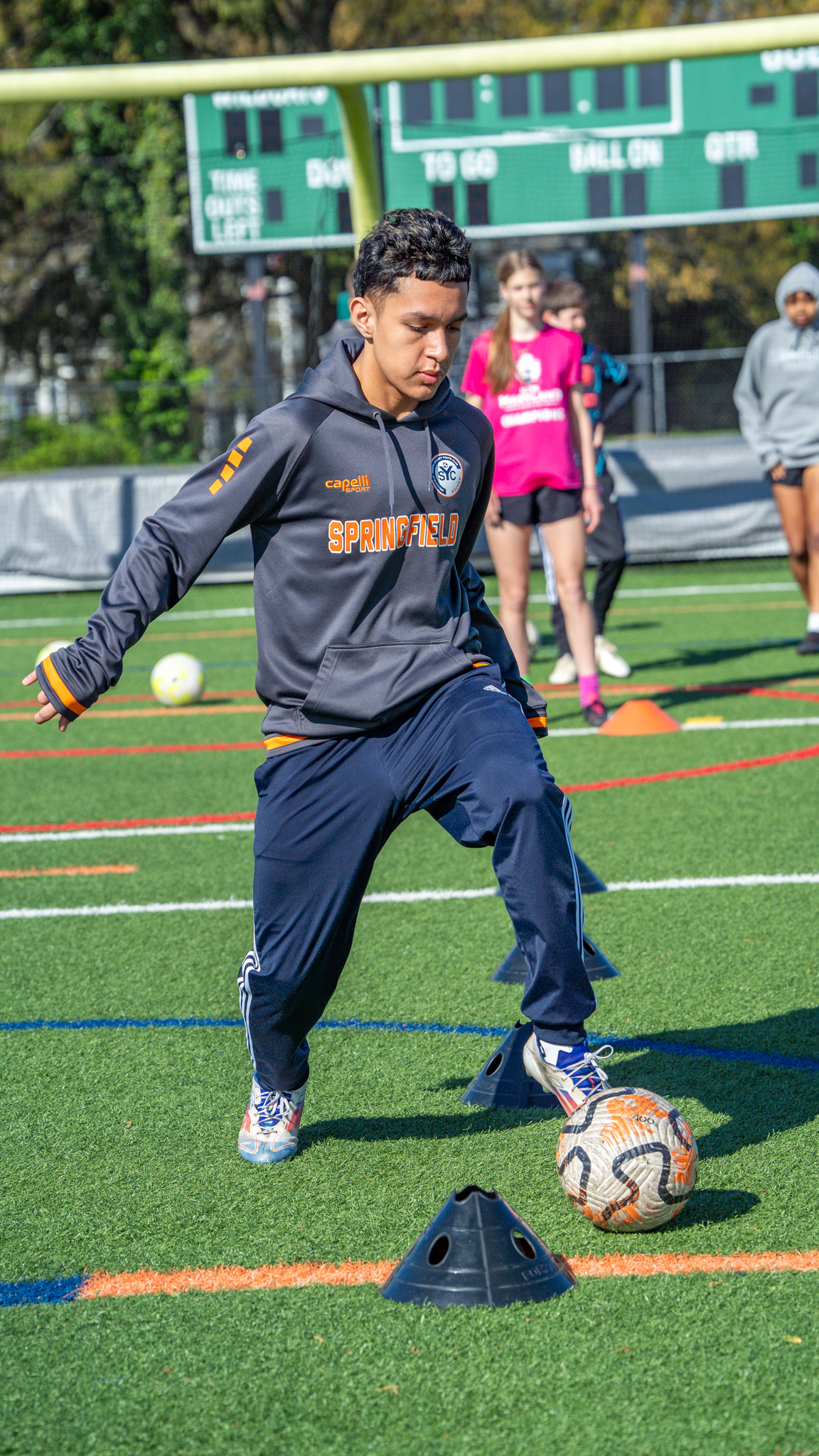 Teen player performing cone dribbling drill